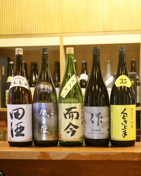 日本酒の一升瓶が並ぶ棚(田酒・磯自慢・而今・作・くどき上手など)
